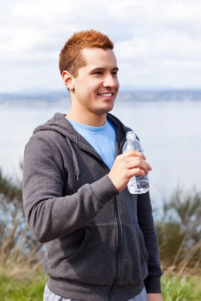 混合レース男水のボトルを保持しています。 — ストック写真