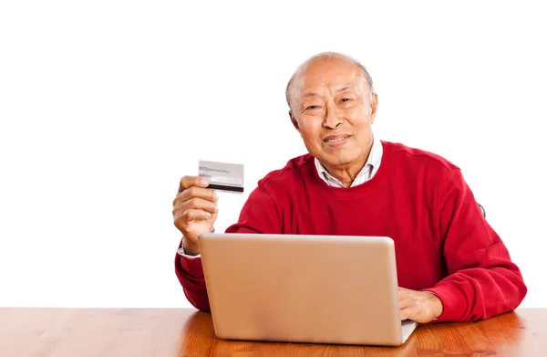 Старший азиатский мужчина делает покупки онлайн празднование Рождества — стоковое фото