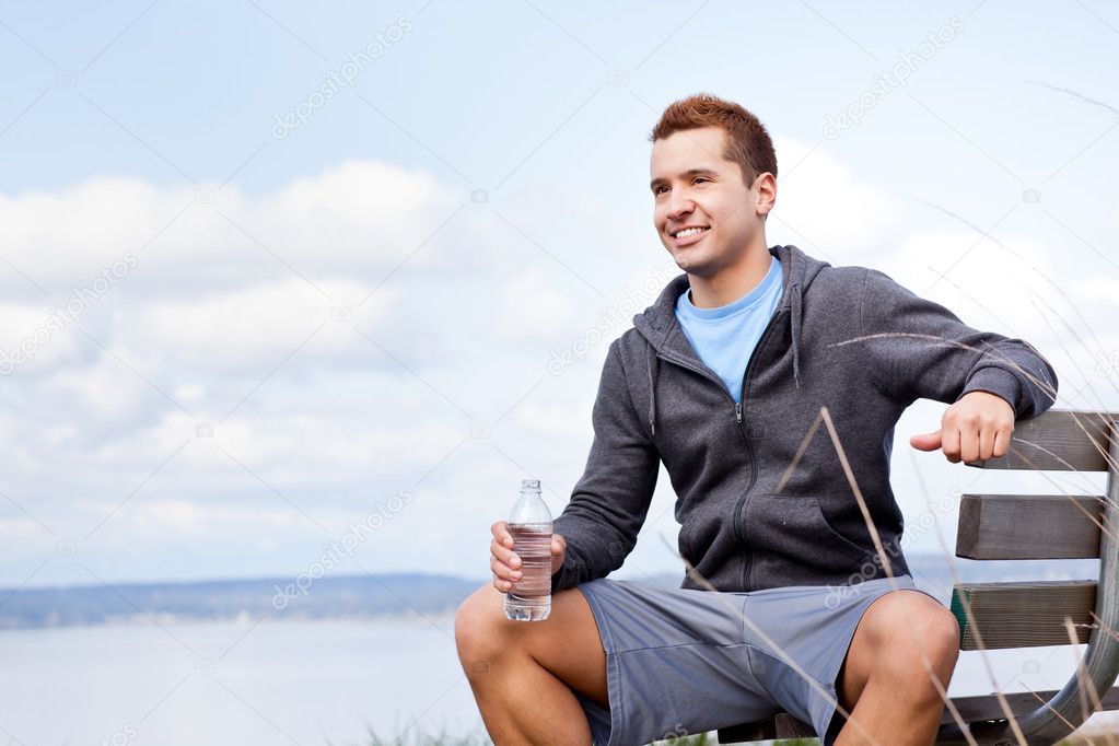 Mixed race man holding water bottle