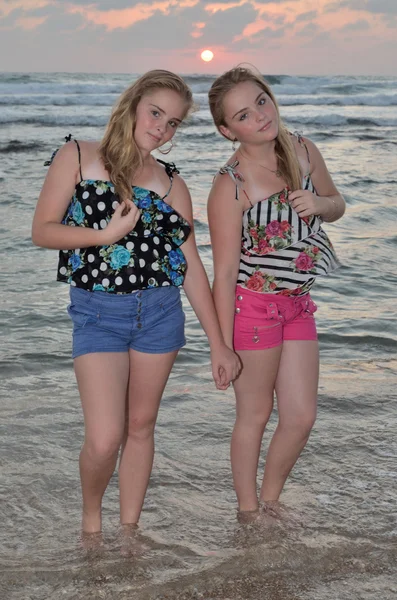 Дві дівчини блондинка на пляжі на заході сонця — стокове фото