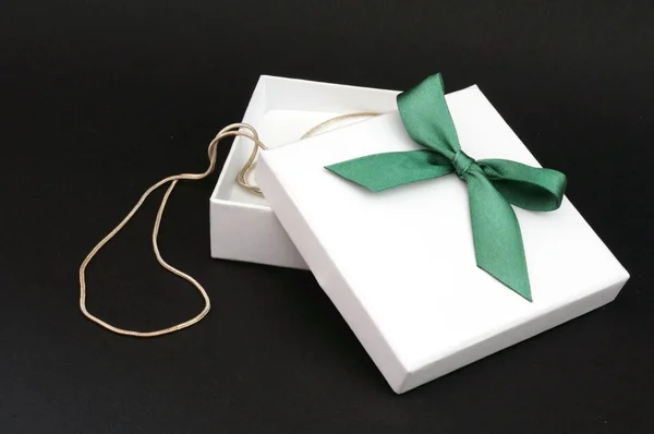 White gift with green ribbon — Stock Photo, Image