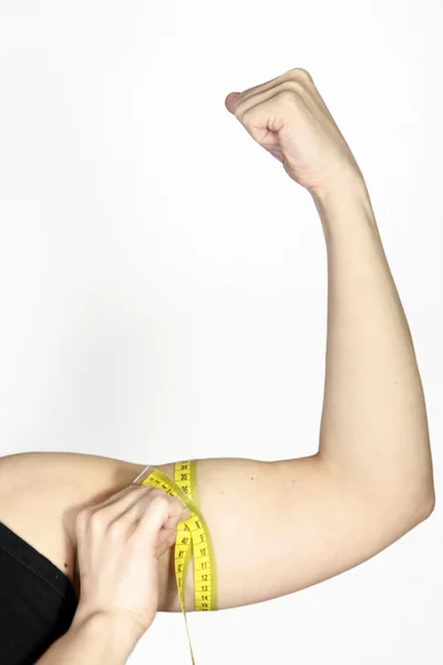 Mulher medindo seu bíceps — Fotografia de Stock