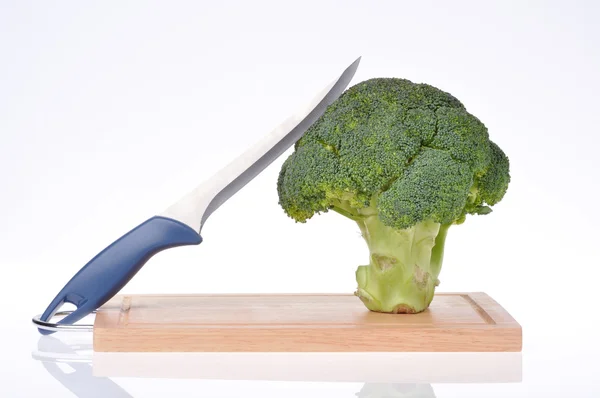 Broccoli met mes op snijplank geïsoleerd — Stockfoto