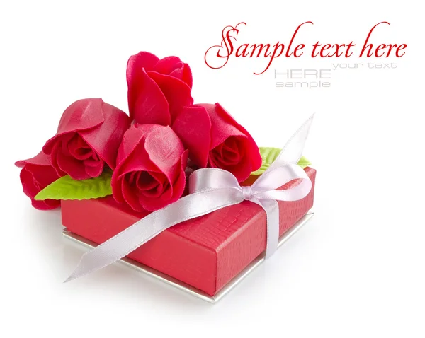 Pequeno presente vermelho com rosas no fundo branco — Fotografia de Stock