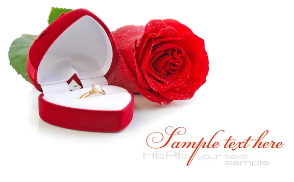 Червона оксамитова коробка з золотим кільцем і червоною трояндою на білому фоні — стокове фото