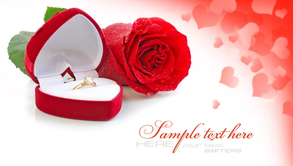 Scatola di velluto rosso con anello d'oro e rosa rossa su uno sfondo festivo — Foto Stock