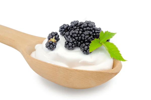 Drewnianą łyżką jest z kremów i świeże blackberry na tył biały — Zdjęcie stockowe
