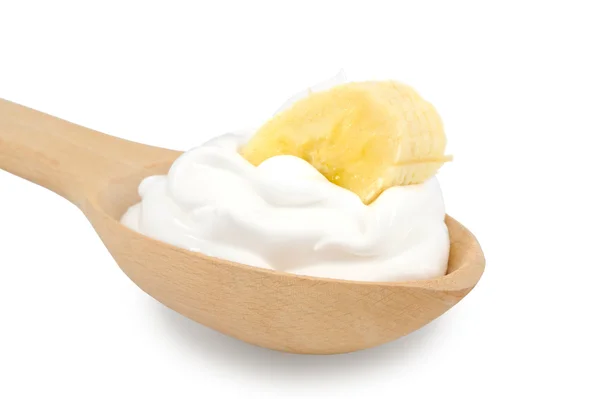 Houten lepel is met crèmes en segment van banaan op een witte backg — Stockfoto
