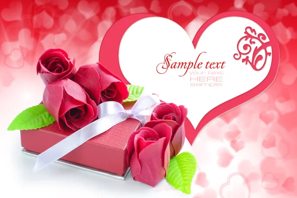 Little red gift with roses on background hearts — Stock Photo, Image