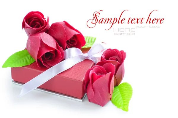 Маленький красный подарок с розами на белом фоне — стоковое фото