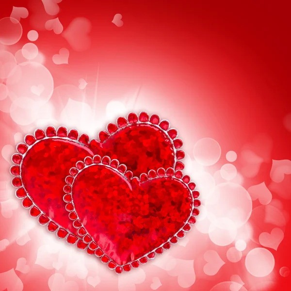 Dois corações decorativos estão em um fundo festivo vermelho — Fotografia de Stock