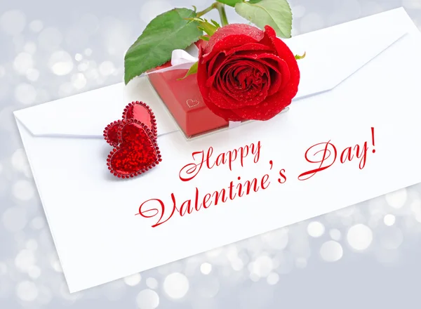 Dois corações decorativos com uma rosa vermelha e caixa por um presente em um pos — Fotografia de Stock