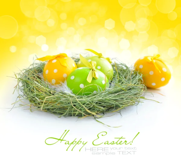 Huevos coloridos de Pascua están en un nido en el fondo festivo —  Fotos de Stock