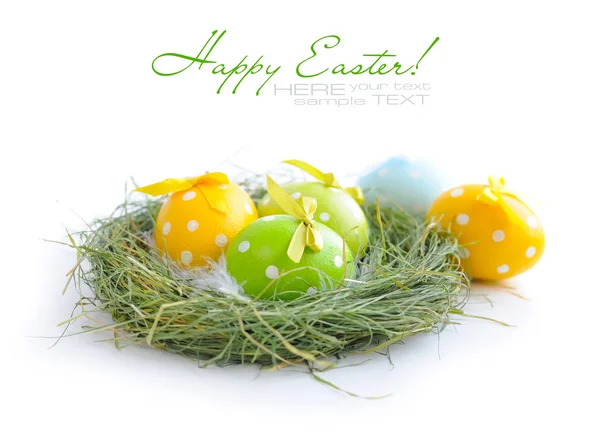 Színes húsvéti tojás van a fészekben, fehér alapon — Stock Fotó