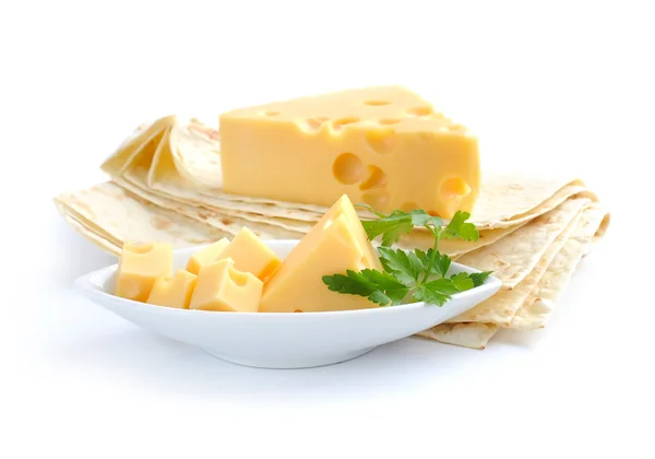 Κομμάτια τυρί σε ένα πιατάκι και είναι σε μια πίτα σε λευκό φόντο — Φωτογραφία Αρχείου