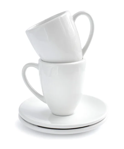 Пустые белые кофейные чашки и тарелки на белом фоне — стоковое фото