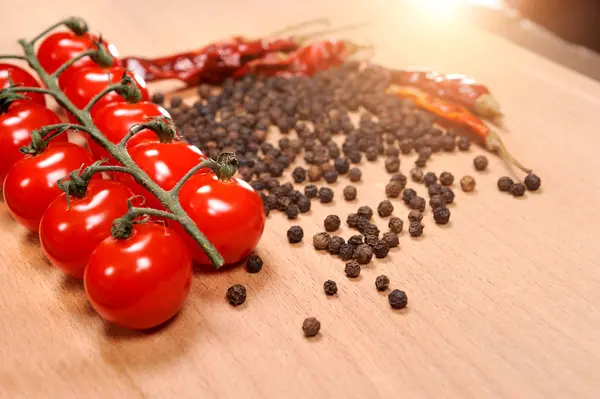 Tomates e pimentas em tábua de madeira — Fotografia de Stock