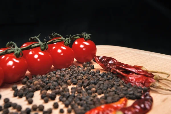 Tomates et poivrons sur planche de bois — Photo