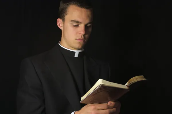 Молодой священник с молитвенником — стоковое фото