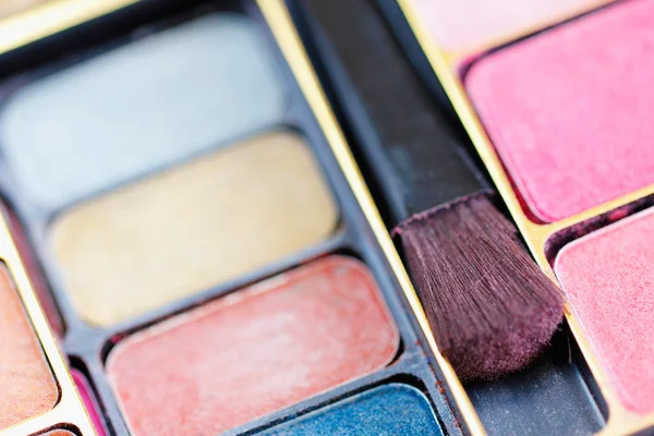 Sombras de ojos multicolores y cepillo de cosméticos —  Fotos de Stock