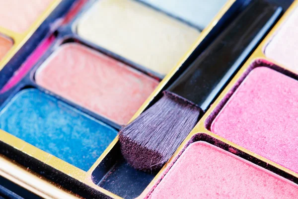 Sombras de olhos multicoloridas e escova de cosméticos — Fotografia de Stock