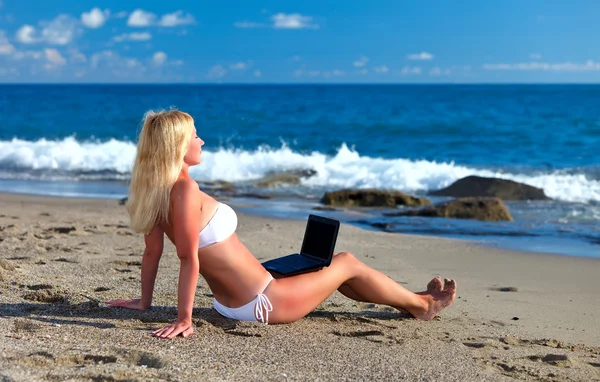 Σέξι όμορφη γυναίκα σε μπικίνι χρησιμοποιώντας φορητό υπολογιστή στην παραλία — Φωτογραφία Αρχείου