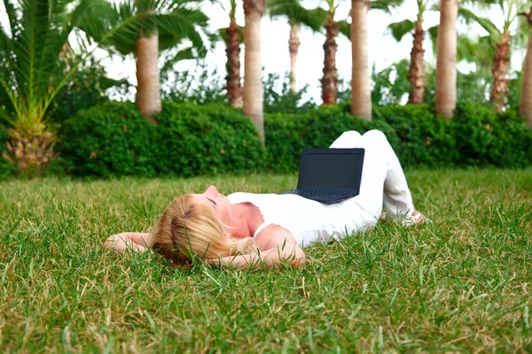 녹색 풀밭에서 노트북으로 작업 하는 젊은 아름 다운 여자 — 스톡 사진