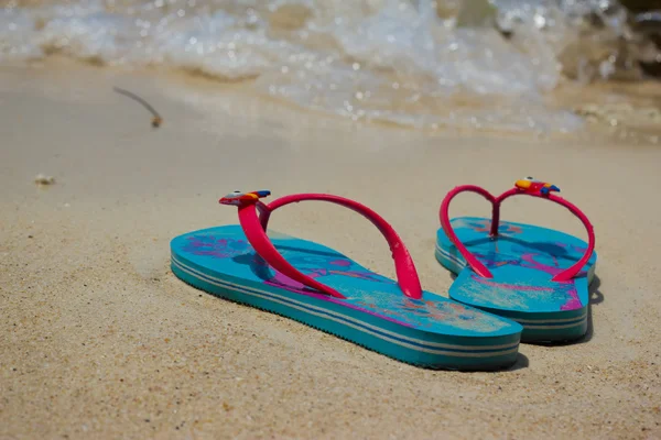Colored flip-flops on the beach — Stock Photo, Image