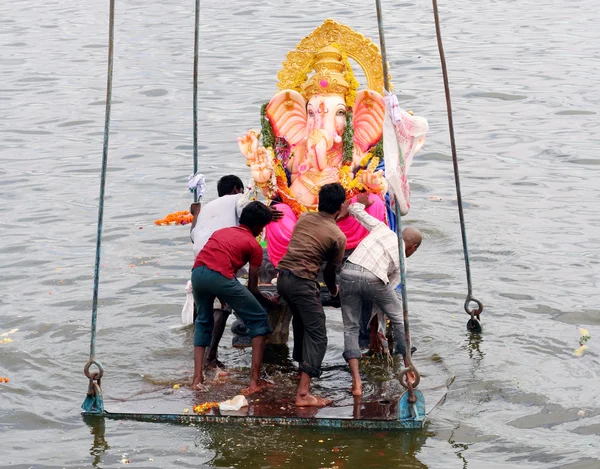 Ganesha idool opgeheven door crane voor onderdompeling Stockfoto