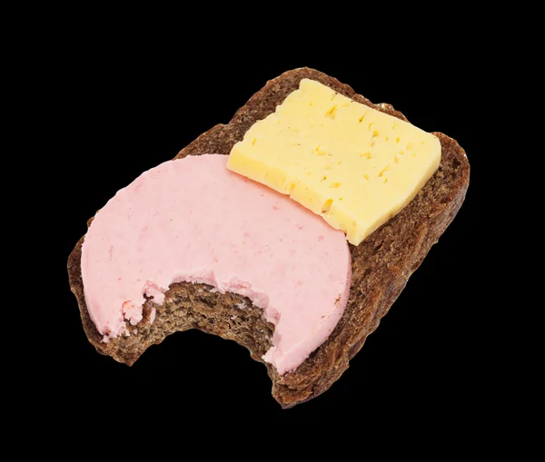Bitten svart bröd med ost och korv — Stockfoto