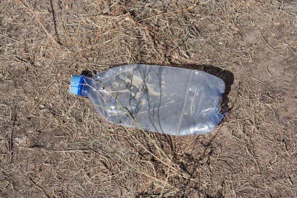Пластиковая бутылка на земле — стоковое фото