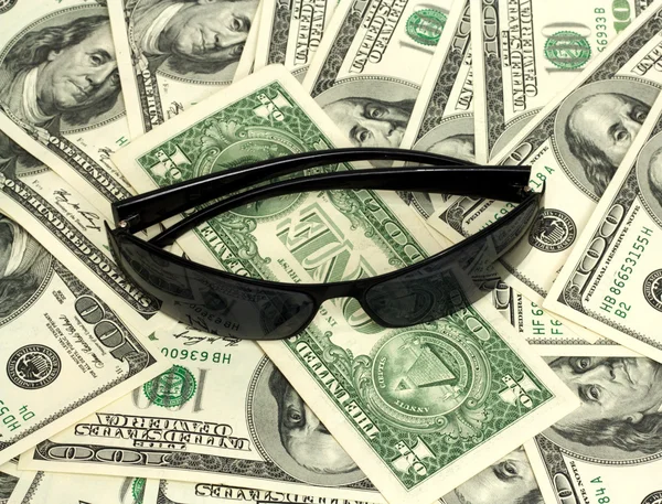 Black spectacles on background of the dollars — Stock Photo, Image