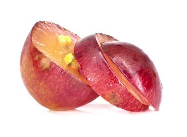 Rebanada translúcida de fruta de uva roja, macro aislada en blanco — Foto de Stock