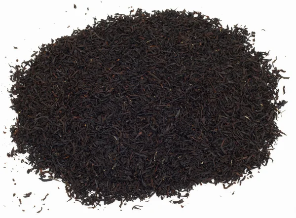 Un puñado de hojas de té negro sobre fondo blanco — Foto de Stock
