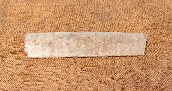 Splinter asbestos pipe on fa background of the rough sackcloth — Stock Photo, Image