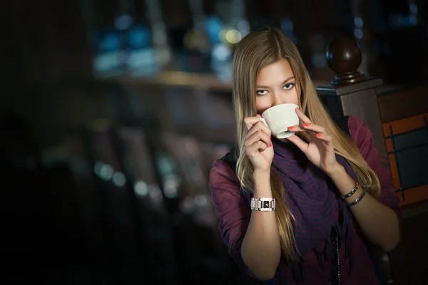 Fiatal gyönyörű nő egy kávézóban egy csésze kávéval — Stock Fotó