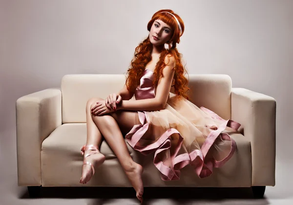 La imagen de una mujer hermosa en el lujoso vestido sentado en sof — Foto de Stock