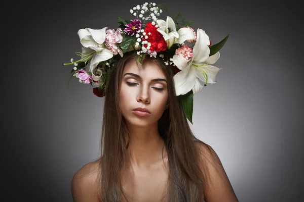 Mulher bonita com coroa de flores no fundo preto — Fotografia de Stock
