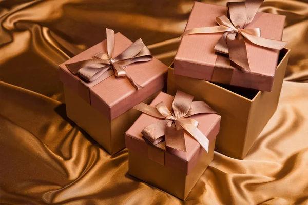 Tre jul presentförpackning på gul satin bakgrund — Stockfoto