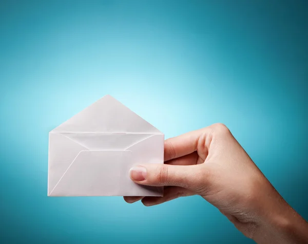 stock image Woman's hand holding opened envelope against blue background
