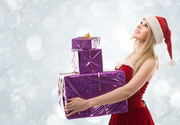 Glückliche Weihnachtsfrau mit Geschenken im Weihnachtsmannkostüm — Stockfoto