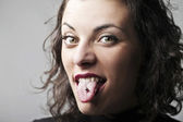 schöne Frau streckt ihre Zunge heraus und zeigt ihr Piercing