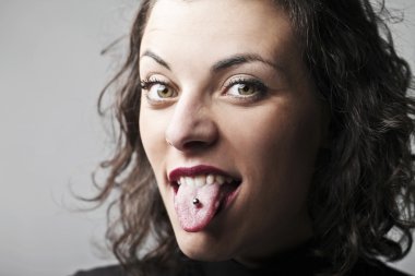 Beautiful woman sticking out her tongue and showing her piercing clipart