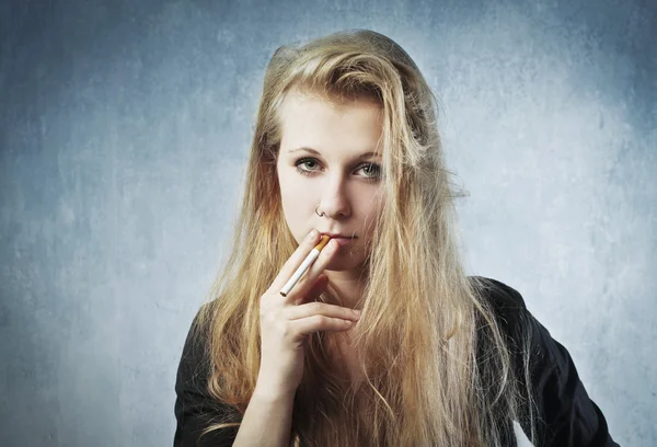 Αρκετά νεαρή γυναίκα που καπνίζει ένα τσιγάρο — Φωτογραφία Αρχείου