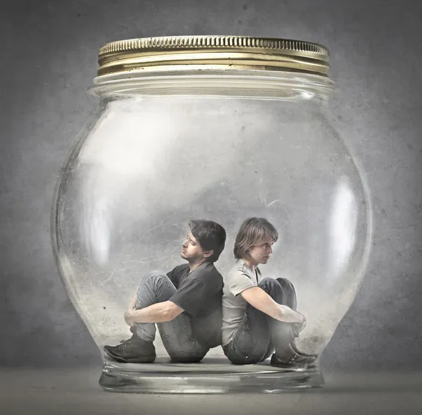 Man and woman sitting in a jar — Stock Photo, Image