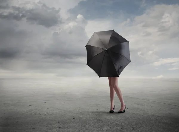 Mulher de pé atrás de um guarda-chuva escondendo seu busto — Fotografia de Stock