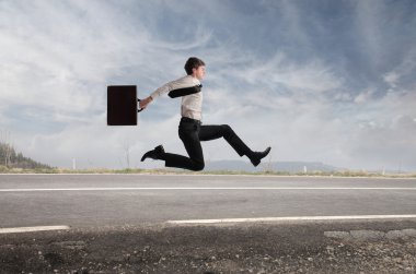 Young businessman running fast on a country road clipart