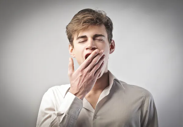 Молодой человек зевает — стоковое фото