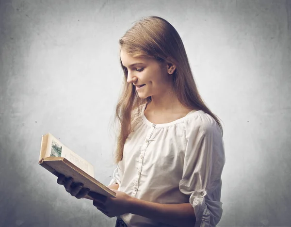 Kitap okuma gülümseyen genç kız — Stok fotoğraf