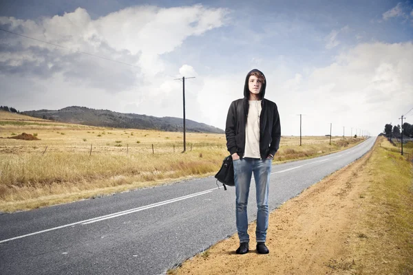 Genç adam bir ülke yolunda duran — Stok fotoğraf
